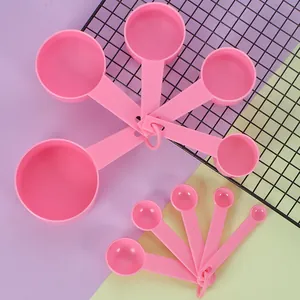 Set of 10 pink plastic measuring spoons and cups with embossed imperial scales for baking