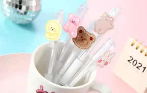 Macro detail showing cute cartoon animal character patches on transparent retractable gel pens.
