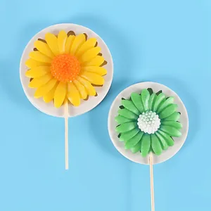 Detailed view of yellow and green sunflower shaped fondant cake decorations on sticks