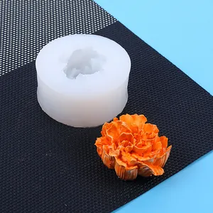 Detailed view of 3D carnation flower silicone mold with finished orange wax flower.