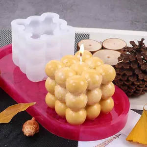 9-gaats bubble cube siliconen mal getoond met een brandende gele kaars en decor