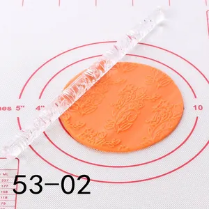 Close-up of acrylic floral embossed rolling pin pressing pattern on fondant