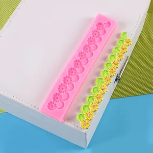 Detail van roze vintage bloem siliconen mal met groene en gele fondant rand voorbeeld