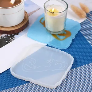 Detailed view of mermaid pattern silicone mold and finished blue resin coaster