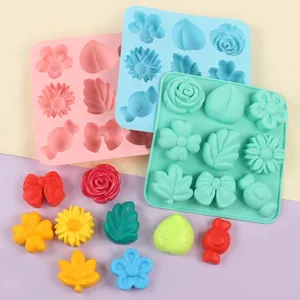 Detailed macro of 9-cavity silicone molds featuring flower, leaf, and candy shapes for DIY