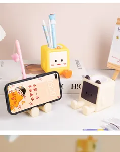 Dettaglio di portapenne a forma di cartone animato utilizzati come pratici supporti per cellulare