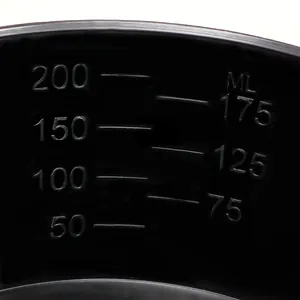 Macro view showing embossed ml measurement scale on black plastic baking measuring tool