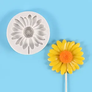 Detailed top view of a white daisy silicone mold next to a finished yellow flower candy