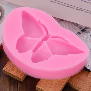 Gros plan du moule en silicone rose en forme de papillon pour fondant et travaux manuels.