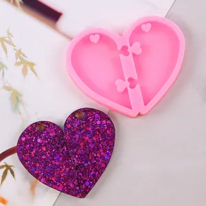 Dettaglio dello stampo in silicone a cuore con campione di resina glitterata viola