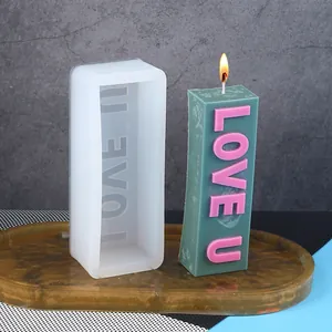 Detail view of rectangular silicone mold and green candle with pink LOVE U text
