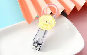 Detail of transparent nail clipper with a cute yellow cartoon dog decorative patch