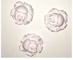 Detailed view of three white rose-shaped silicone molds for DIY cake decorating