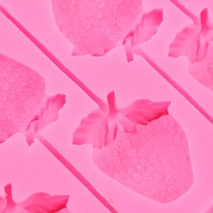 Primer plano de un molde de silicona rosa con forma de fresa y texturas de superficie detalladas