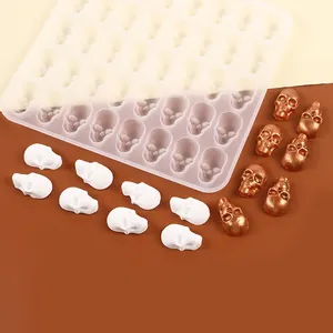 Macro view of skull-shaped silicone mold with finished white and bronze candies
