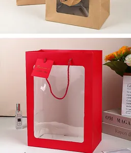 Dettaglio di elegante sacchetto regalo in carta rossa con finestra e manico in corda