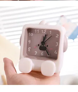 Close-up of a small cartoon alarm clock showing the cute animal face dial