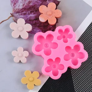 Detail view of pink silicone flower mold with various colored wax or soap samples.