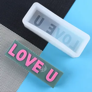 Detailed macro view of rectangular silicone mold and plaster bar with LOVE U text