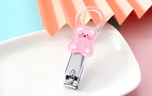 Detail macro view of cute pink bear-shaped transparent nail clippers on a white display tray