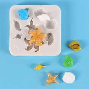 Close-up detail of ocean-themed silicone mold with starfish and conch shell samples