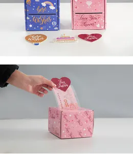 Dettaglio di una scatola regalo rosa a sorpresa per estrazione di denaro e auguri.