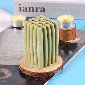 Nahaufnahme einer grünen gerippten Aromatherapie-Säulenkerze auf Holz