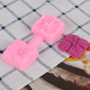 Macro view of pink silicone petal mold featuring a finished purple fondant flower