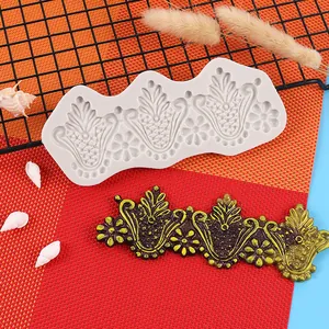 Detailopname van een vintage bloemen siliconen mal met een gouden fondant decoratie.