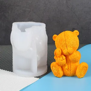 Detail view of 3D bear silicone mold and finished orange textured candle figurine.