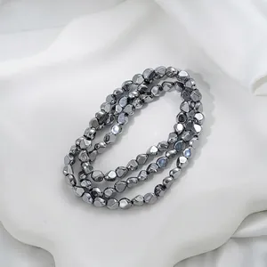 Makroansicht unregelmäßig facettierter, galvanisierter Glasperlen in Gunmetal
