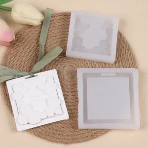 Gros plan de moules en silicone et d'une pierre en relief avec motifs de roses et papillons.