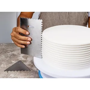 Detail view of a professional stainless steel cake scraper creating ribbed patterns on icing
