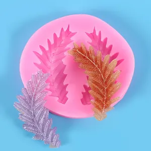 Texturas detalladas de plumas y hojas en un molde de silicona con piezas terminadas.