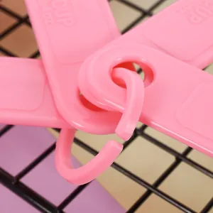Close-up of pink plastic measuring spoon handles and connecting ring with embossed scale.
