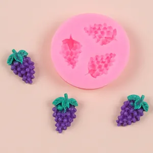 Close-up detail of pink silicone grape mold with finished purple fondant grapes
