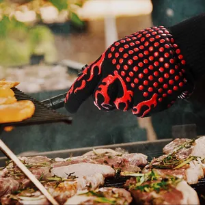 Heat-resistant BBQ glove with red anti-slip silicone grip used for outdoor grilling meat