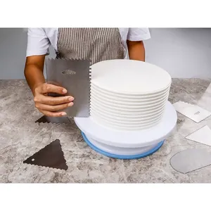 Action shot of metal cake scraper creating textured patterns on white icing cake