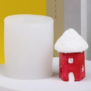 Stampo in silicone per casetta di neve con una piccola casa rossa finita accanto.