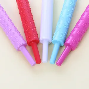 Close-up of plastic rolling pins with embossed floral and heart patterns for fondant