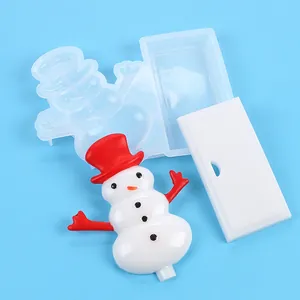 Detailed view of DIY Christmas snowman silicone mold with finished resin pieces on blue