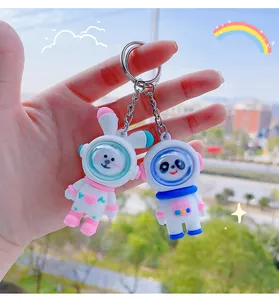 Gedetailleerd beeld van schattige panda en konijn astronaut siliconen sleutelhangers in de hand