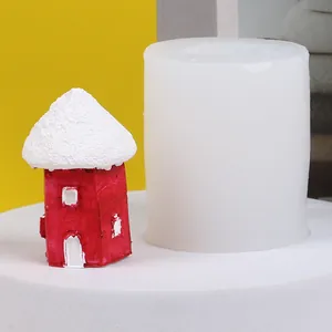 Vista dettagliata dello stampo in silicone bianco accanto alla casetta rossa innevata finita