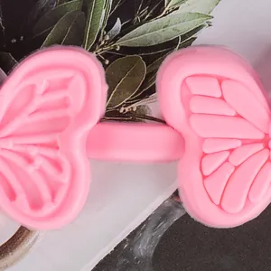 Close-up macro view of a pink butterfly silicone fondant mold showing intricate textures.
