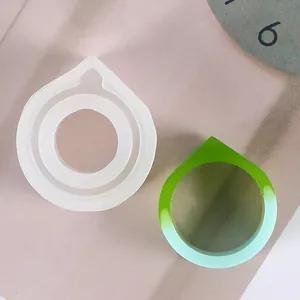 Détail montrant un moule en silicone pour bague avec une bague en résine verte finie.