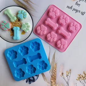 Vista detallada de moldes de silicona con forma de pata y hueso para velas y postres