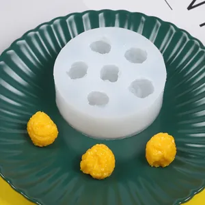 Vista detallada de un molde de silicona de 6 cavidades con palomitas amarillas en plato.