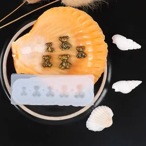 Detailed view of mini bear silicone mold with gold resin bear figures on a decorative shell