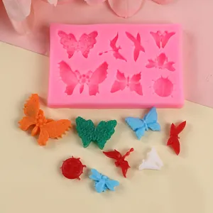 Vue détaillée du moule en silicone rose avec formes de papillons et insectes pour gâteau