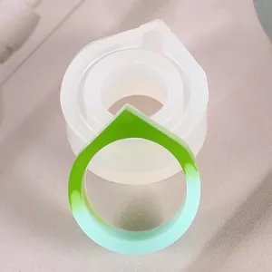 Détail d'une bague en résine dégradé vert avec son moule à bijoux en silicone souple
